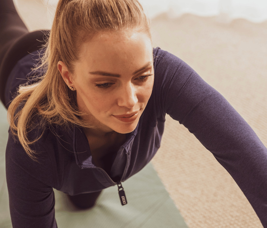 Woman stretching on an exercise mat at home