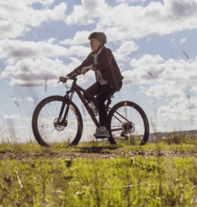 Cyclist on a dirt trail through open grassland
