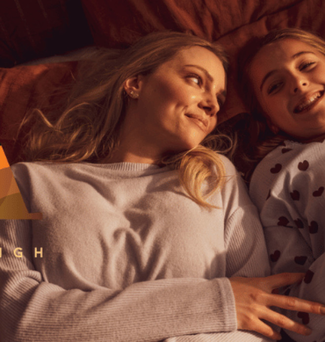 Mother and daughter lying together, with the Amberleigh Golden Grove logo