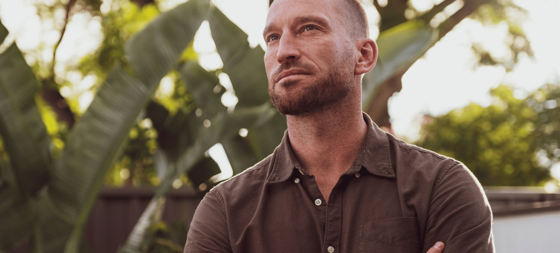 Man standing outdoors with his arms folded