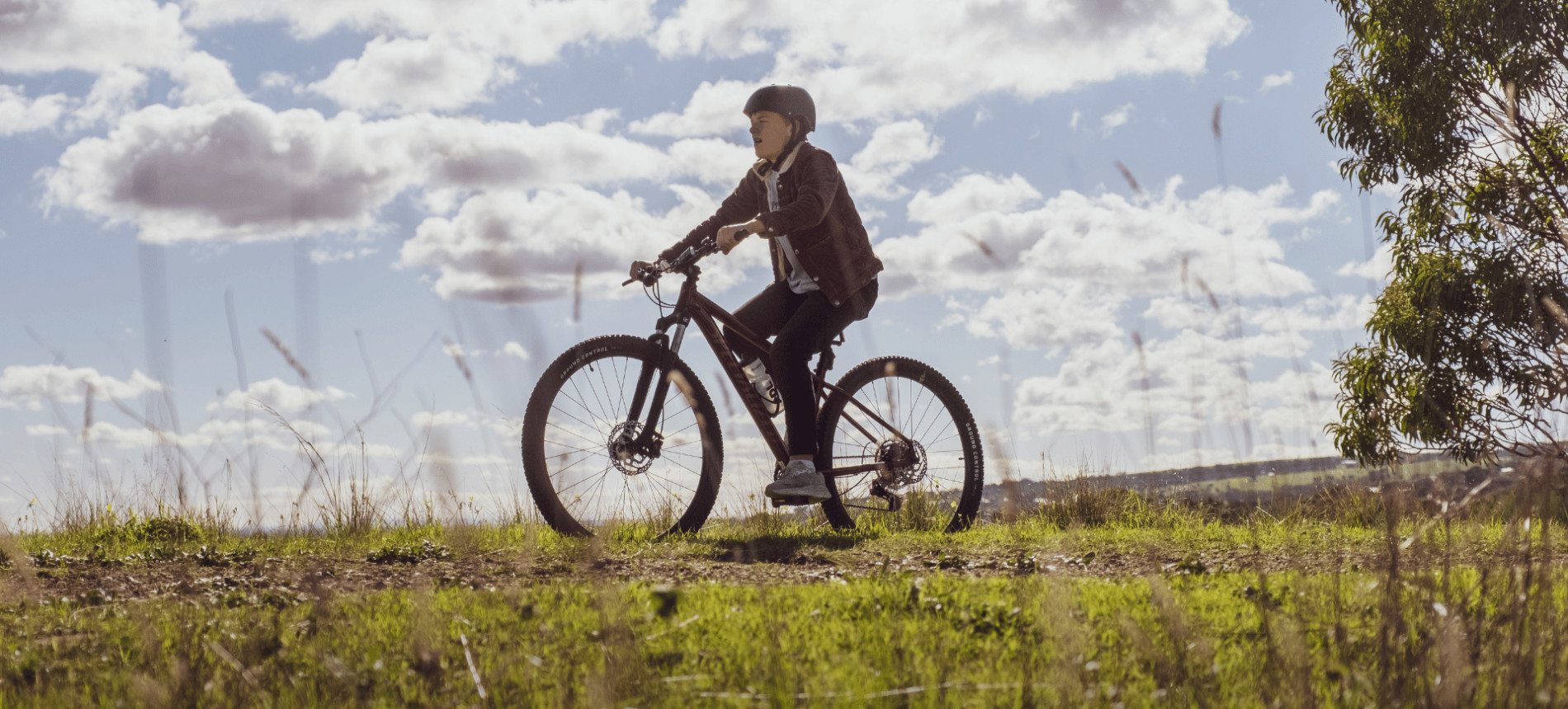 Cyclist on a dirt trail through open grassland