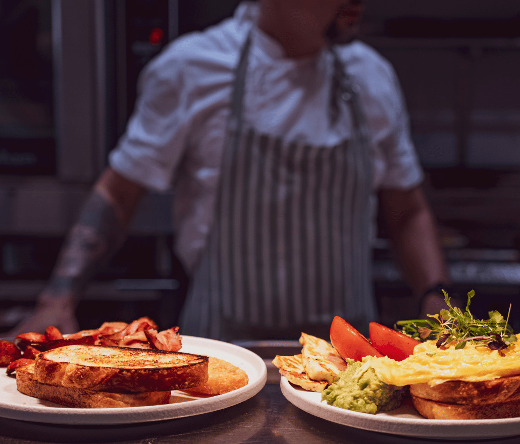 Chef plating two breakfast dishes at Leaf & Co at The Grove